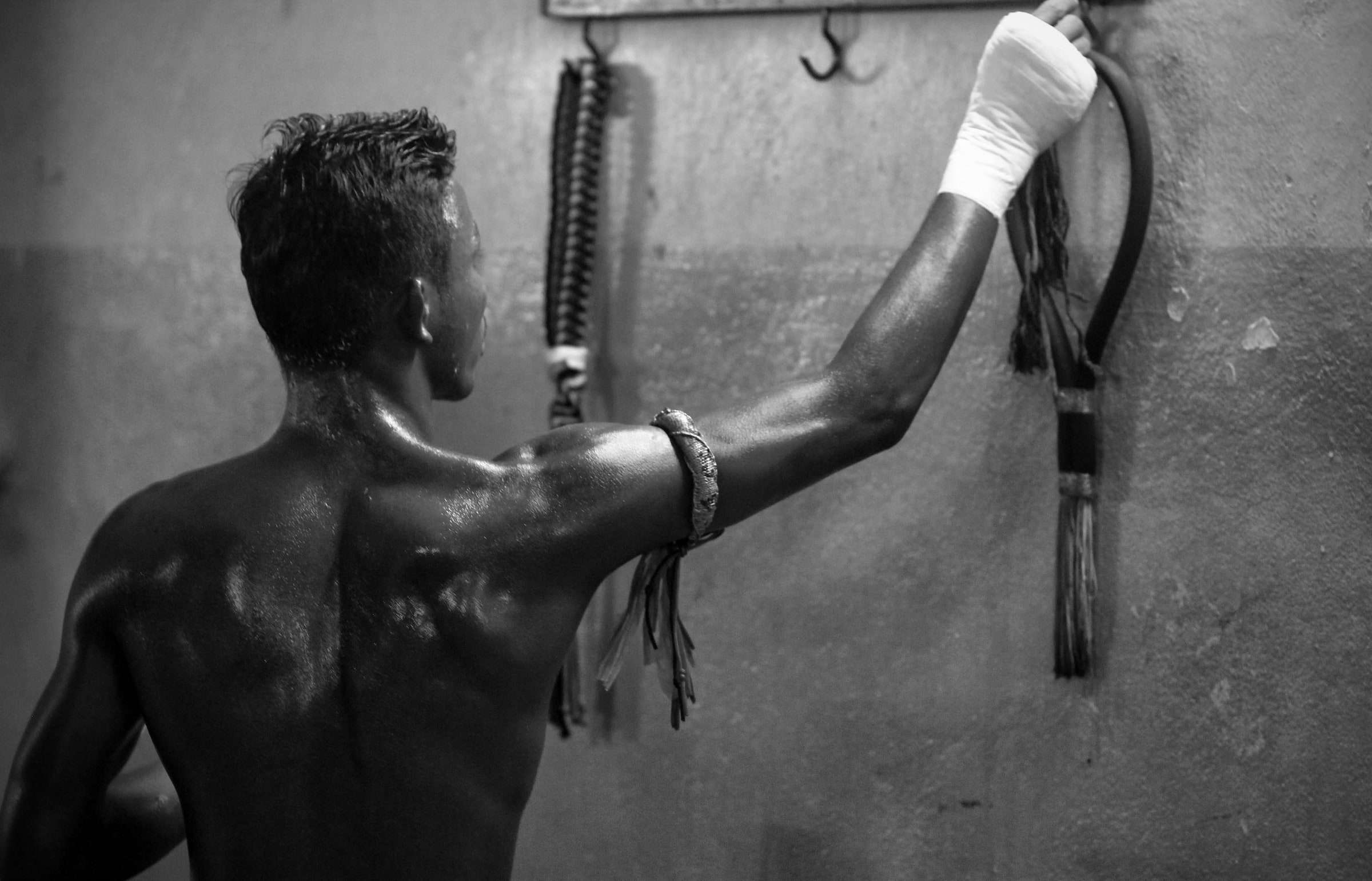 Muay-Thai-Kämpfer mit bandagierter Hand und traditionellem Armband (Prajied) in einem Gym in Thailand